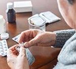 close_up_woman_sorting_through_daily_pills-1317799872